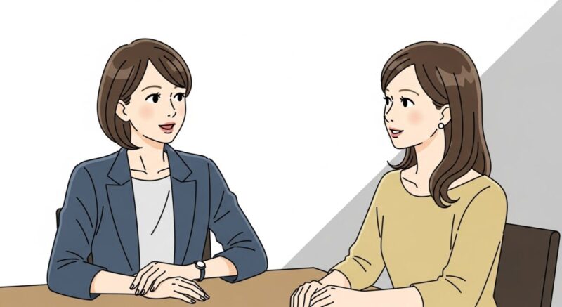 カフェで対話する2人の日本人女性。一人が話し、もう一人がうなずいて聞いている温かなシーン。